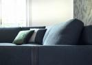 Detail of the straps in precious leather which wrap around the armrests of the Dee Dee corner sofa upholstered in fabric